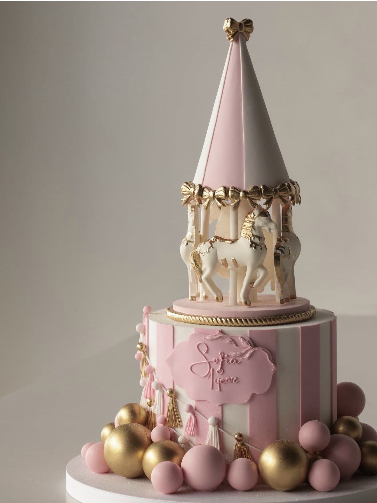 Pauline Cake Dubai pink and gold carousel-themed birthday cake